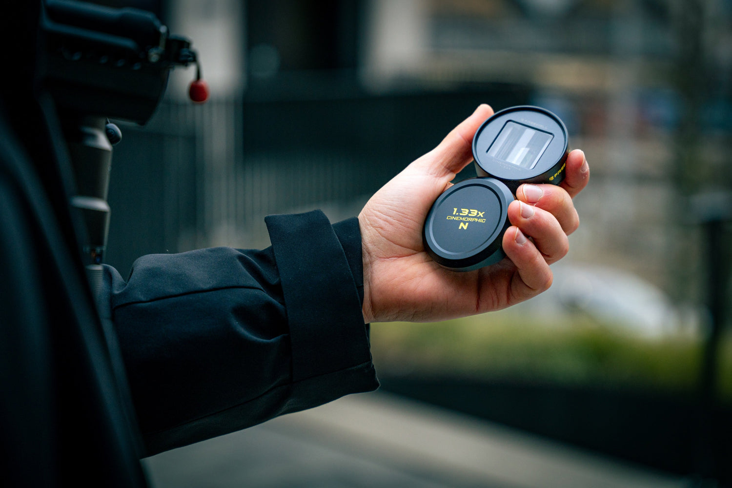 Hands holding freewell neutral anamorphic lens