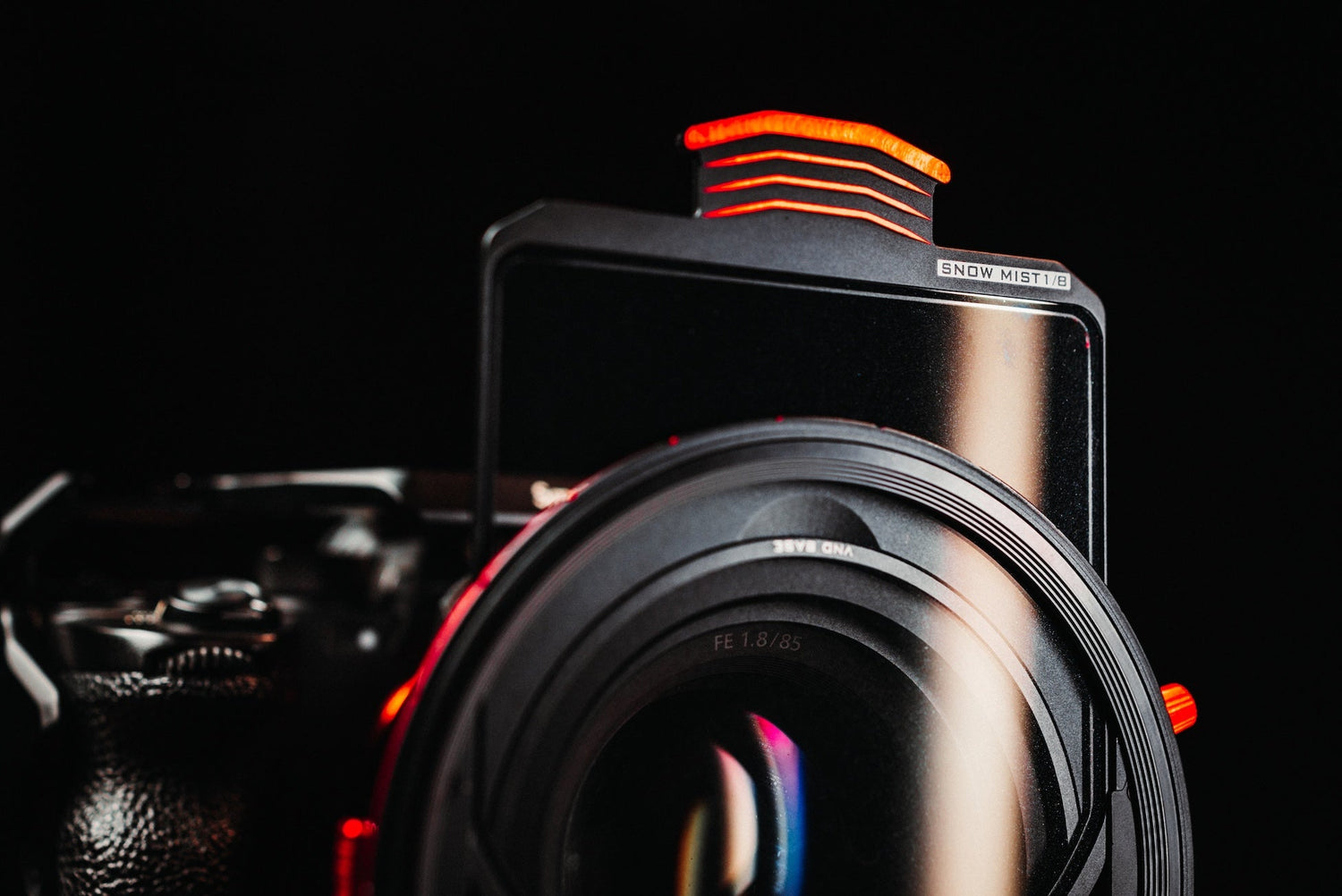 Close-up of Freewell Snow Mist 1/8 filter mounted on a camera lens with glowing red accents, against a dark background.