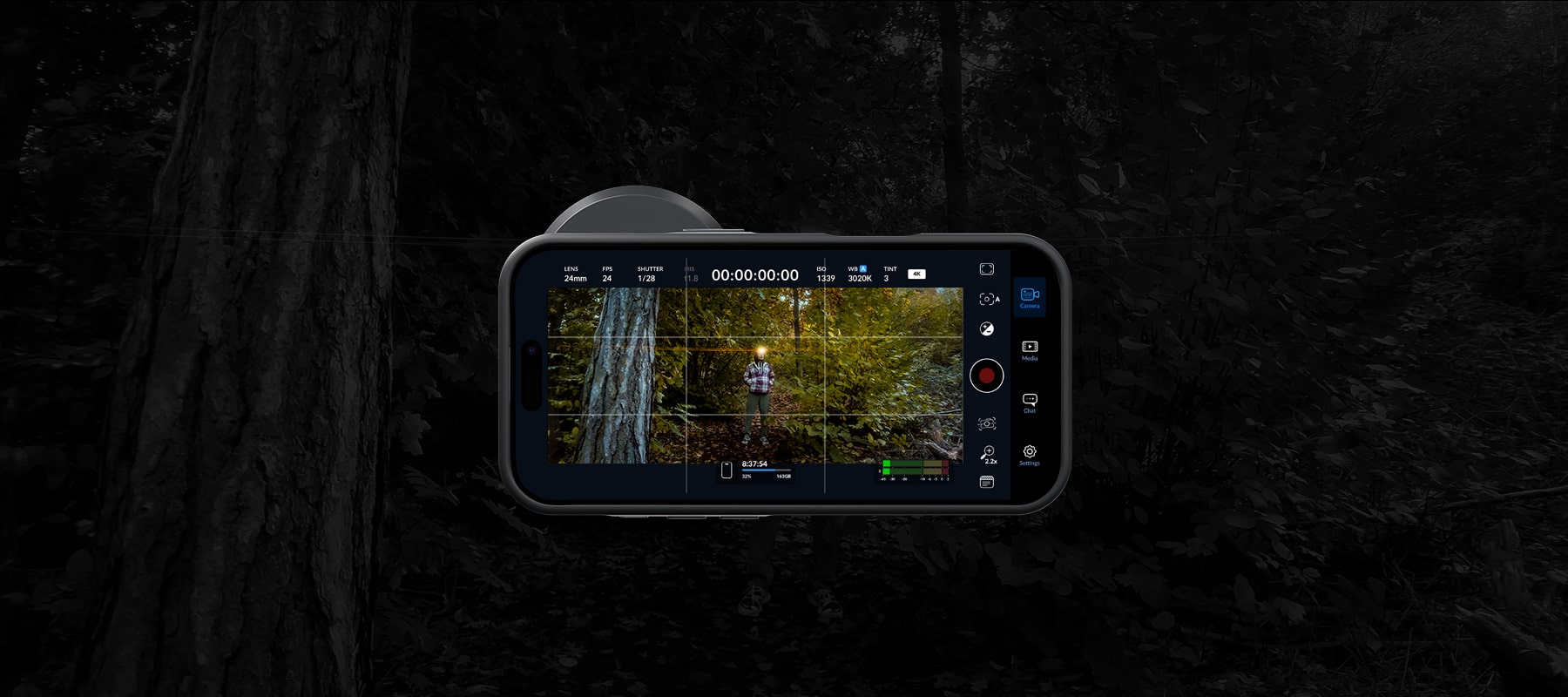 A phone screen displaying a landscape recording interface with Freewell 1.33x gold anamorphic lens, settings like lens, shutter speed, and exposure, capturing a person walking in a forest scene.