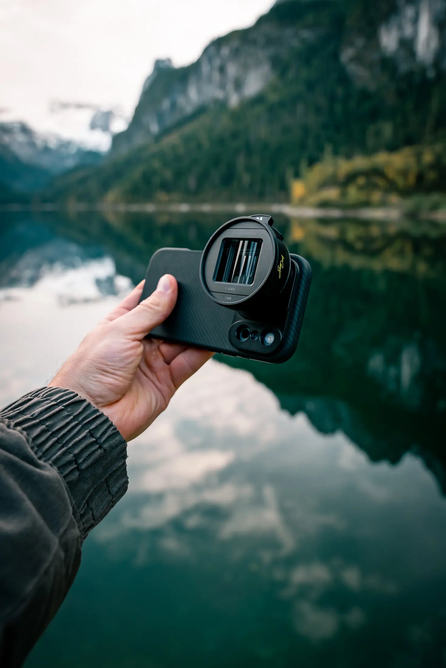 Close view of the Pro Filmmaker Case and lens beside a mountain lake