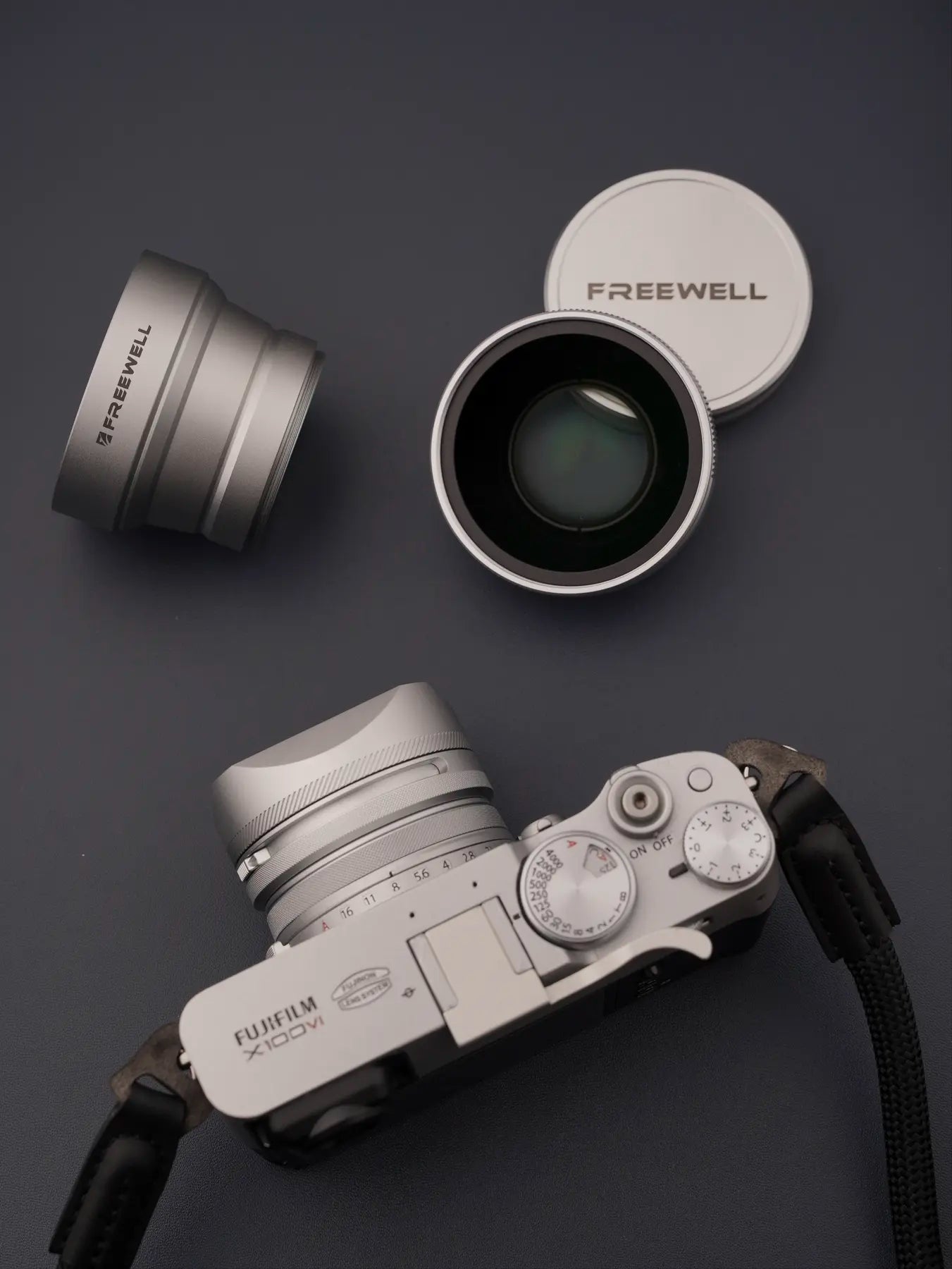 Silver Freewell telephoto lens beside a Fujifilm X100VI camera