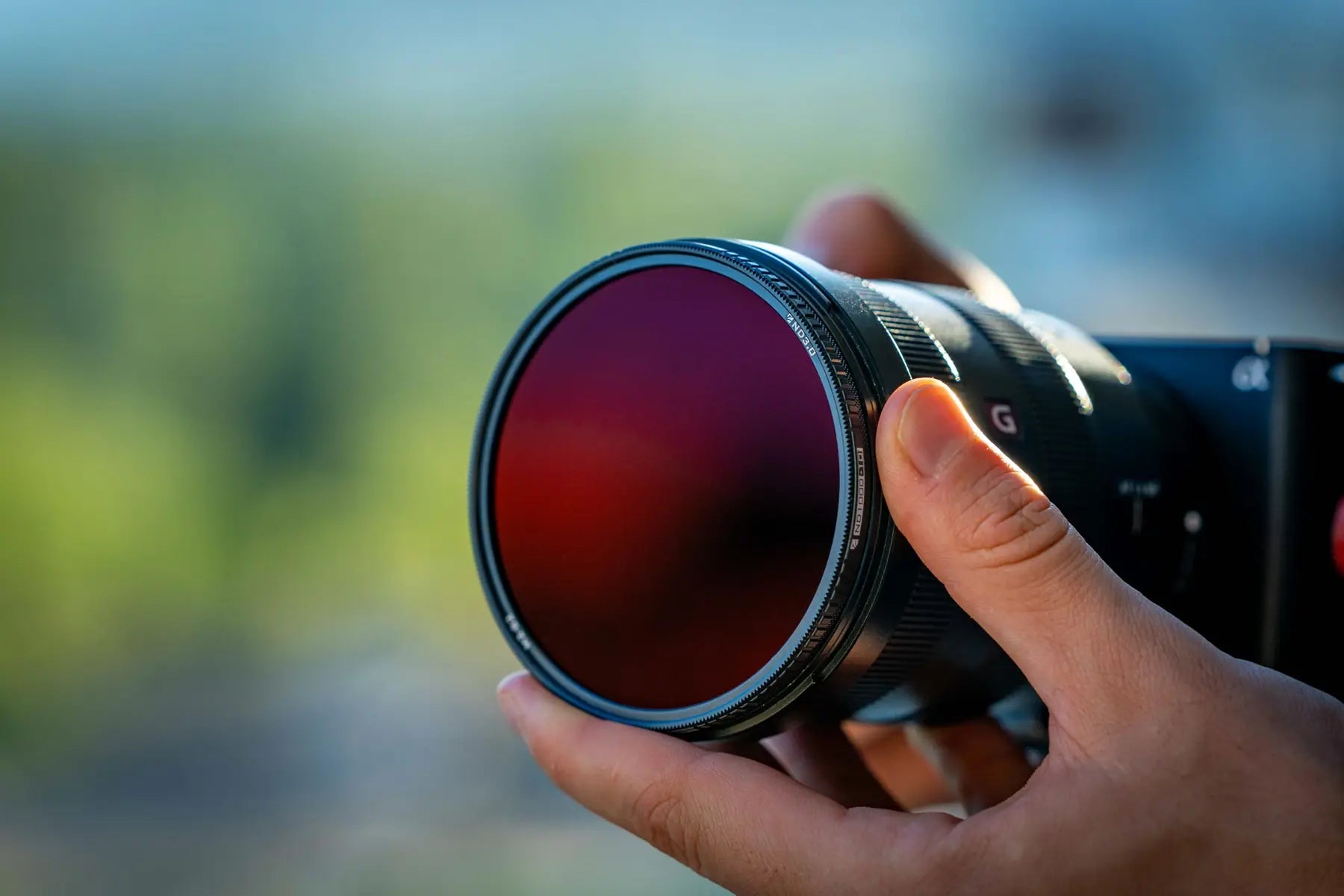 Freewell M2 filter held in front of a camera lens outdoors