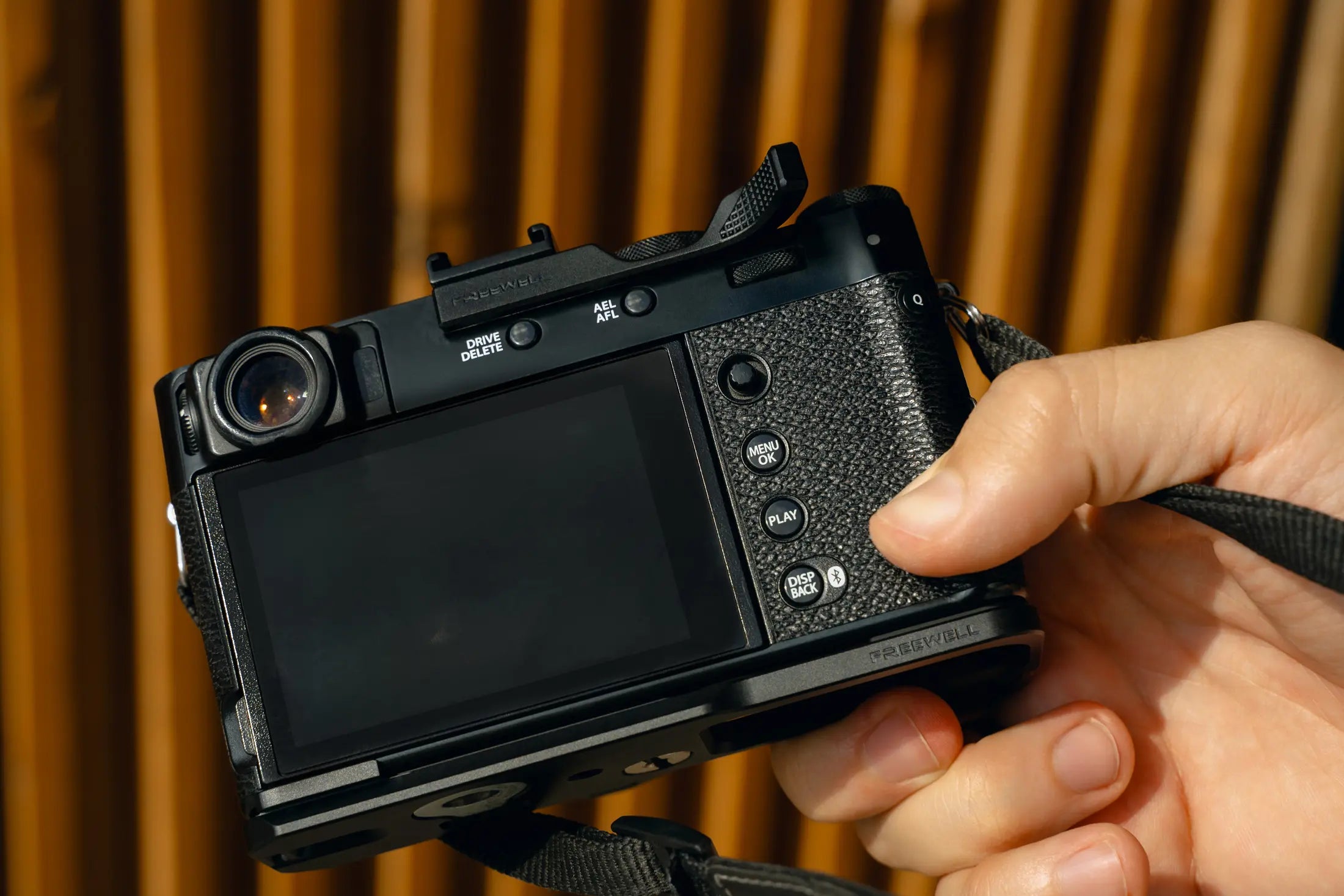 Rear view of a Fujifilm X100VI showing clear access to the camera controls with the thumb grip installed