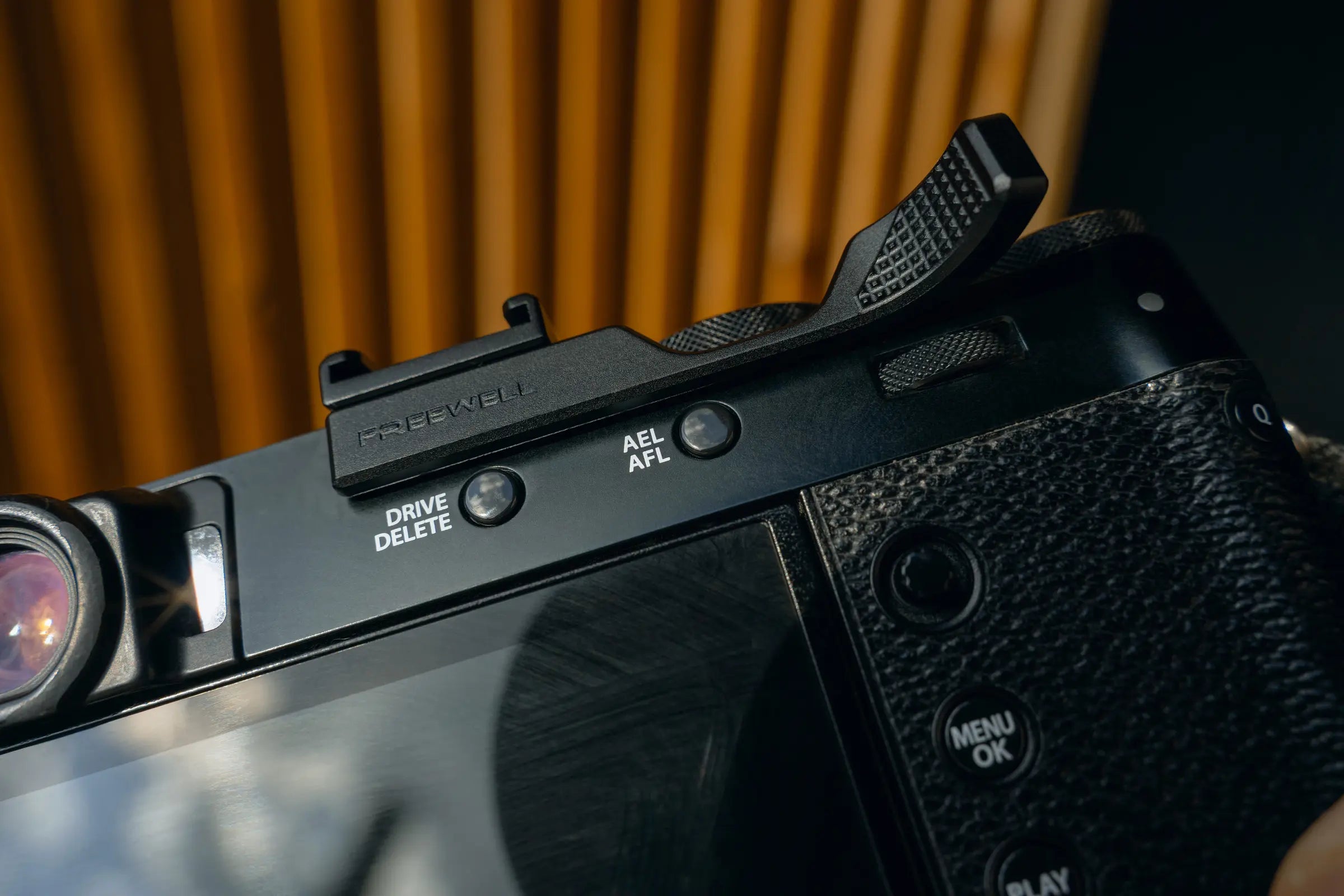 Freewell thumb grip installed on the rear of a black Fujifilm X100VI
