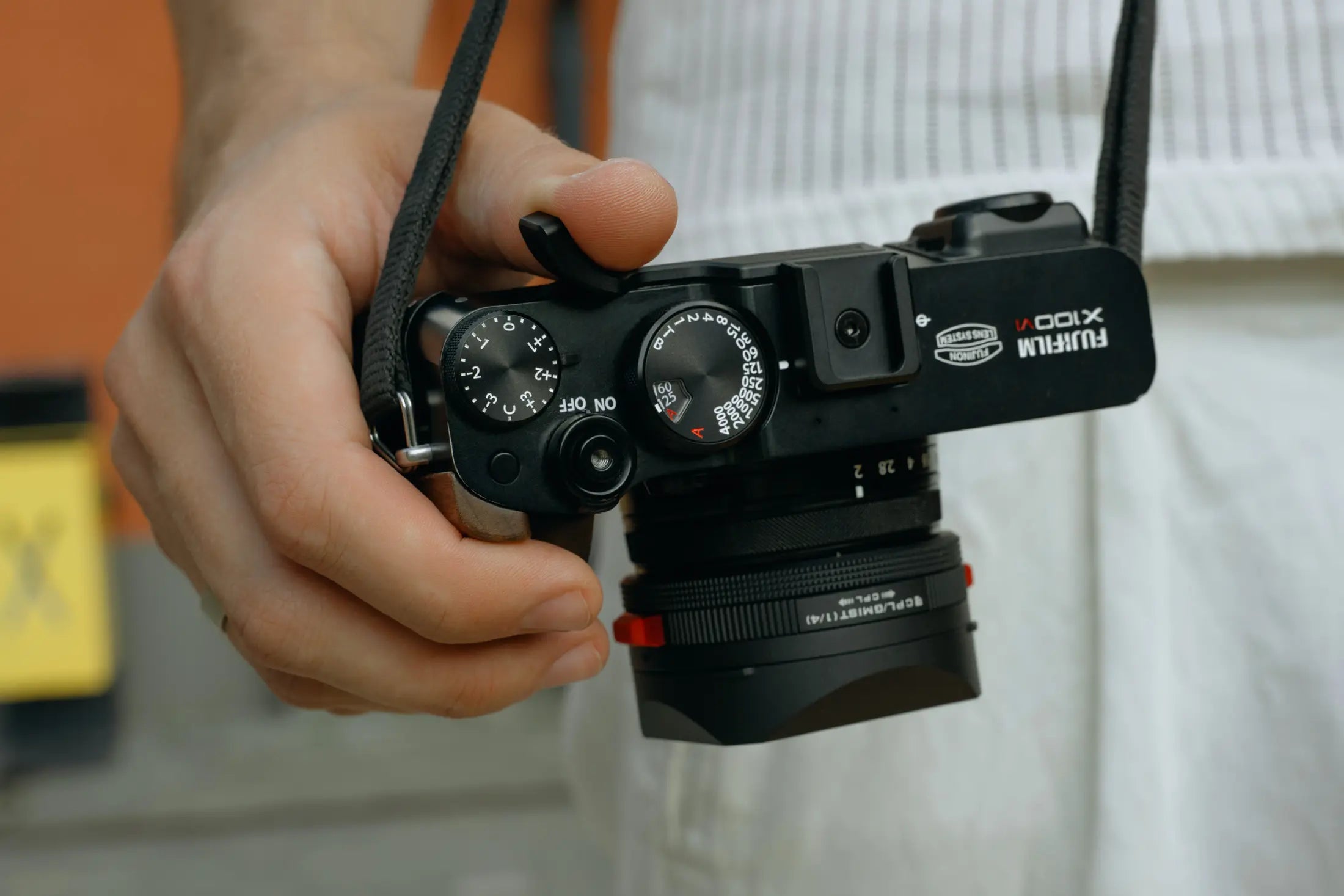 Photographer holding a Fujifilm X100VI securely with the thumb grip