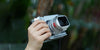 Hand holding a Fujifilm GFX100RF with Lens hood