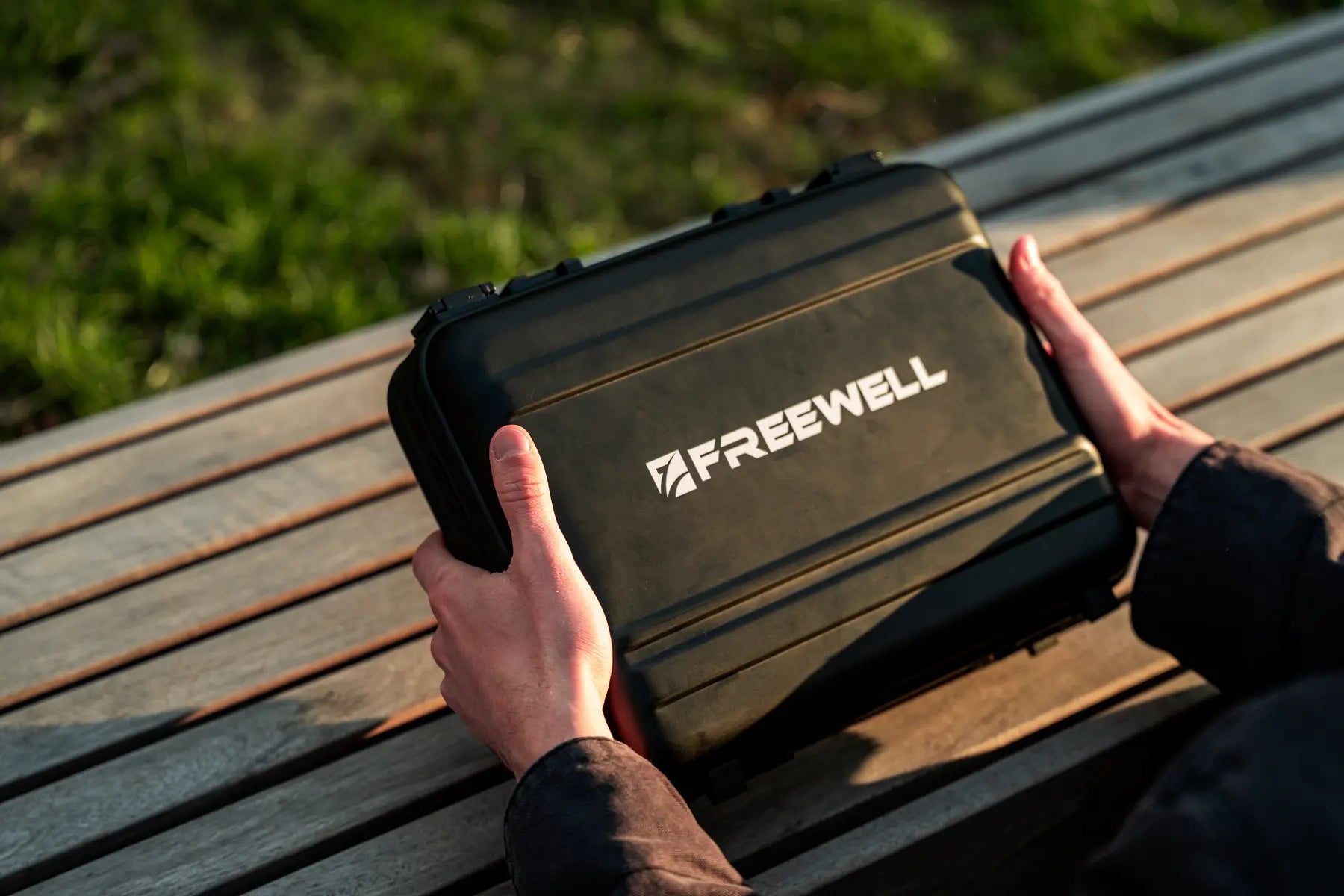 Hands closing the Freewell protective lens carry case