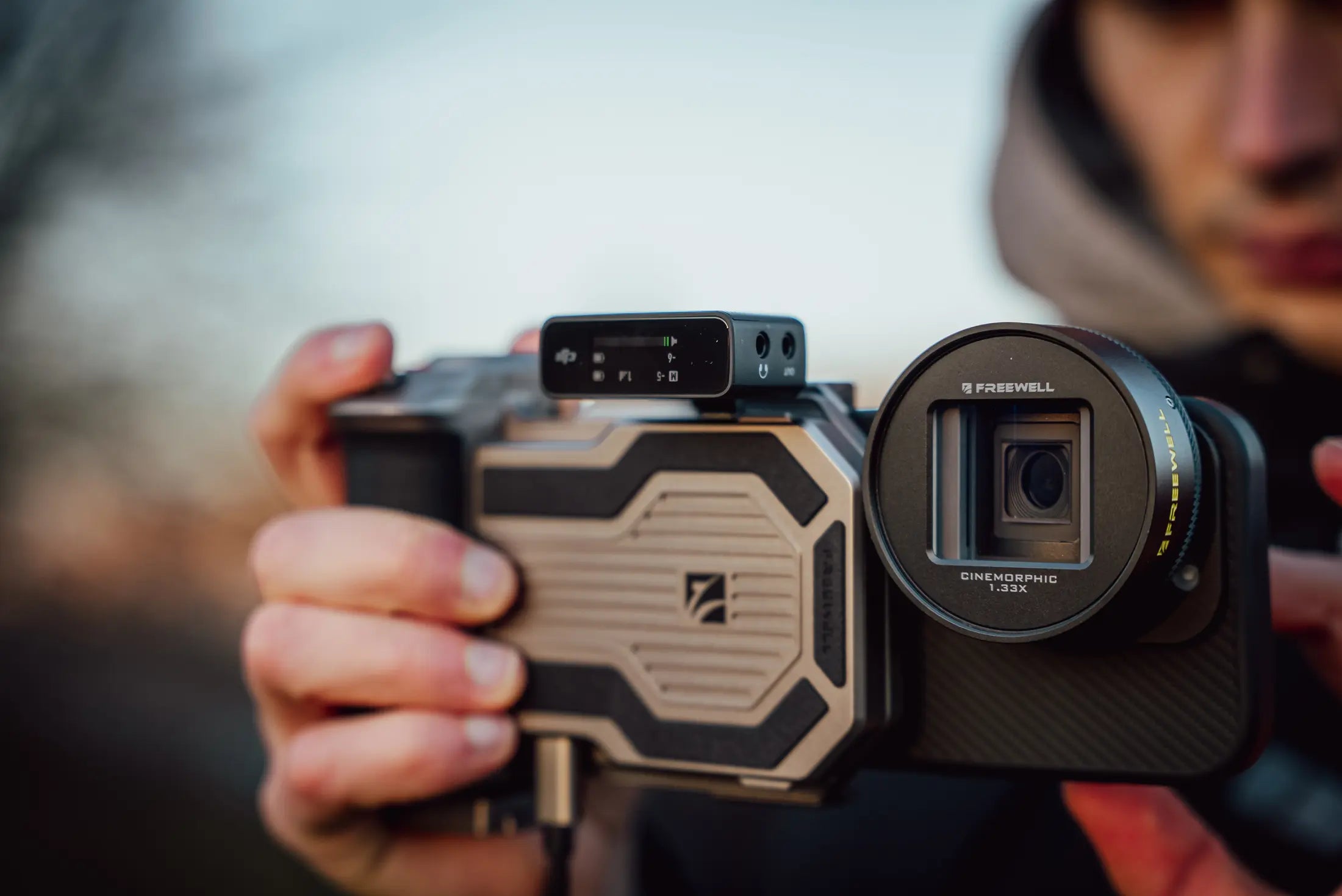 Freewell Pro SSD Hub mounted to a smartphone filmmaking rig with an anamorphic lens and wireless microphone