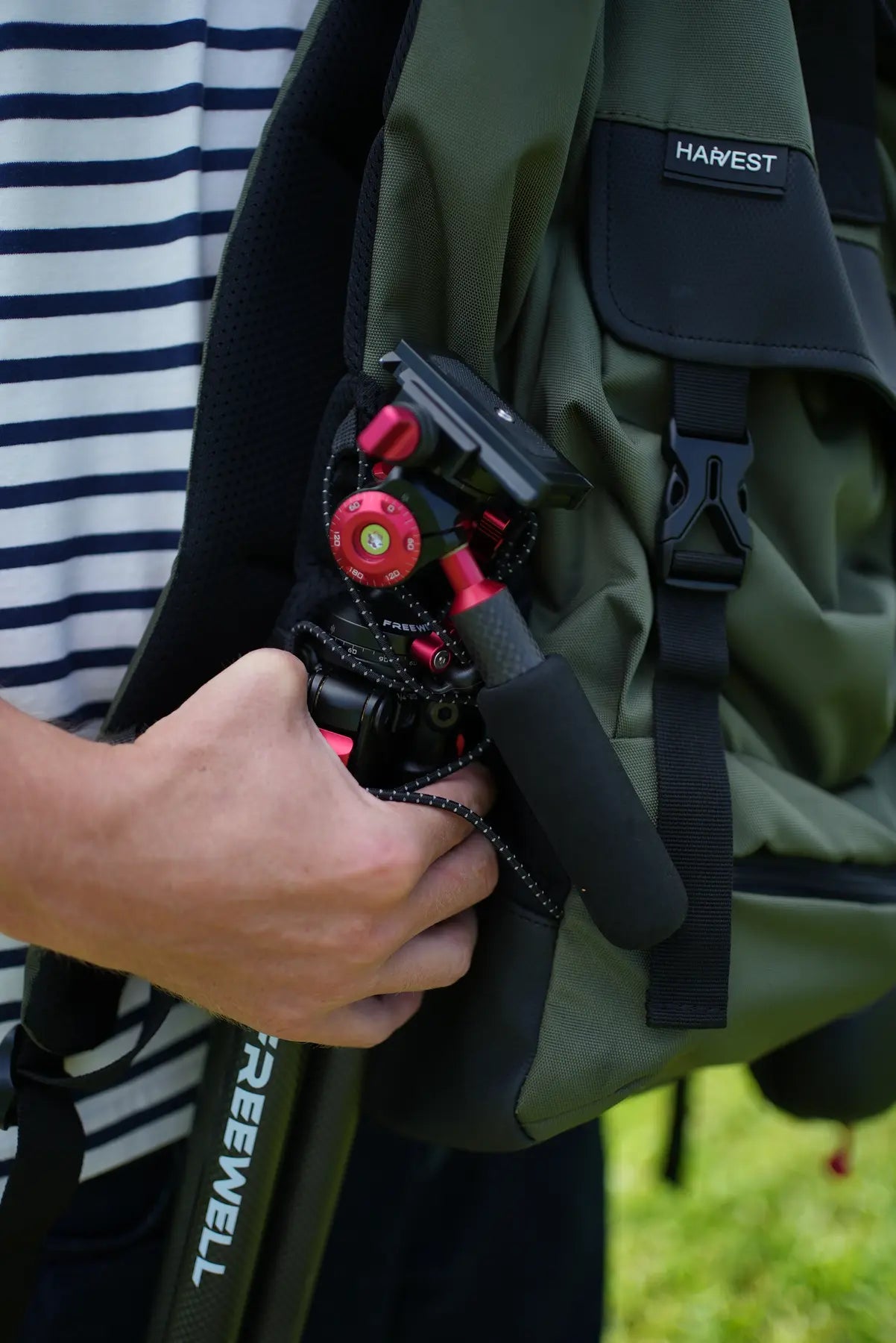 Close view of the folded Freewell T1 beside a travel backpack