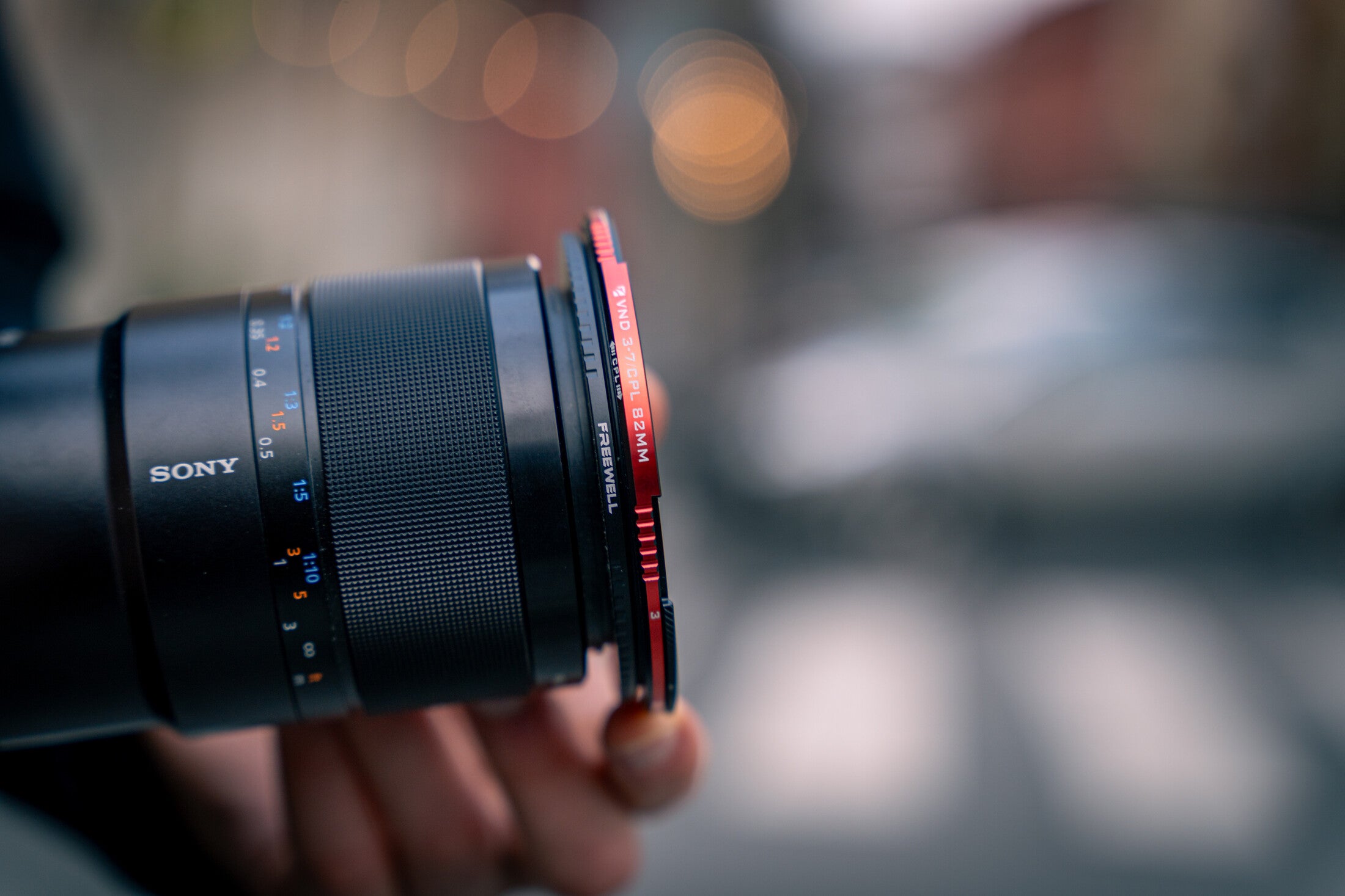 Filmmaker adjusting a Freewell hybrid VND and CPL filter during an outdoor shoot