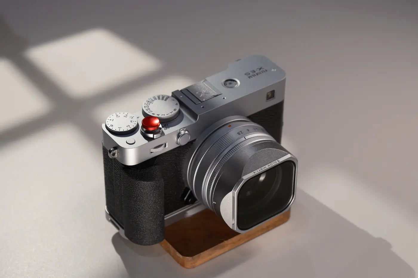 Silver Fujifilm X-E5 with the lens hood in angled studio light