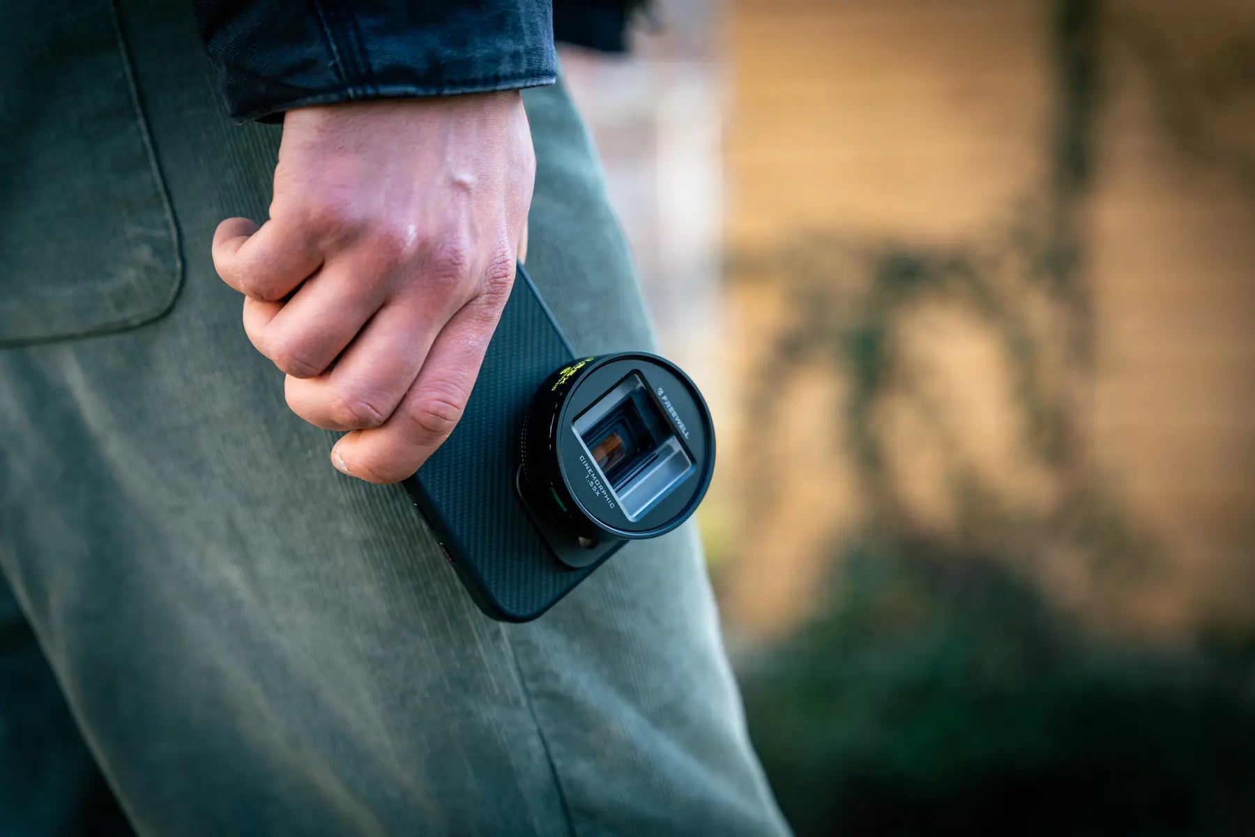 Compact 1.55x lens attached to a phone at the creator's side