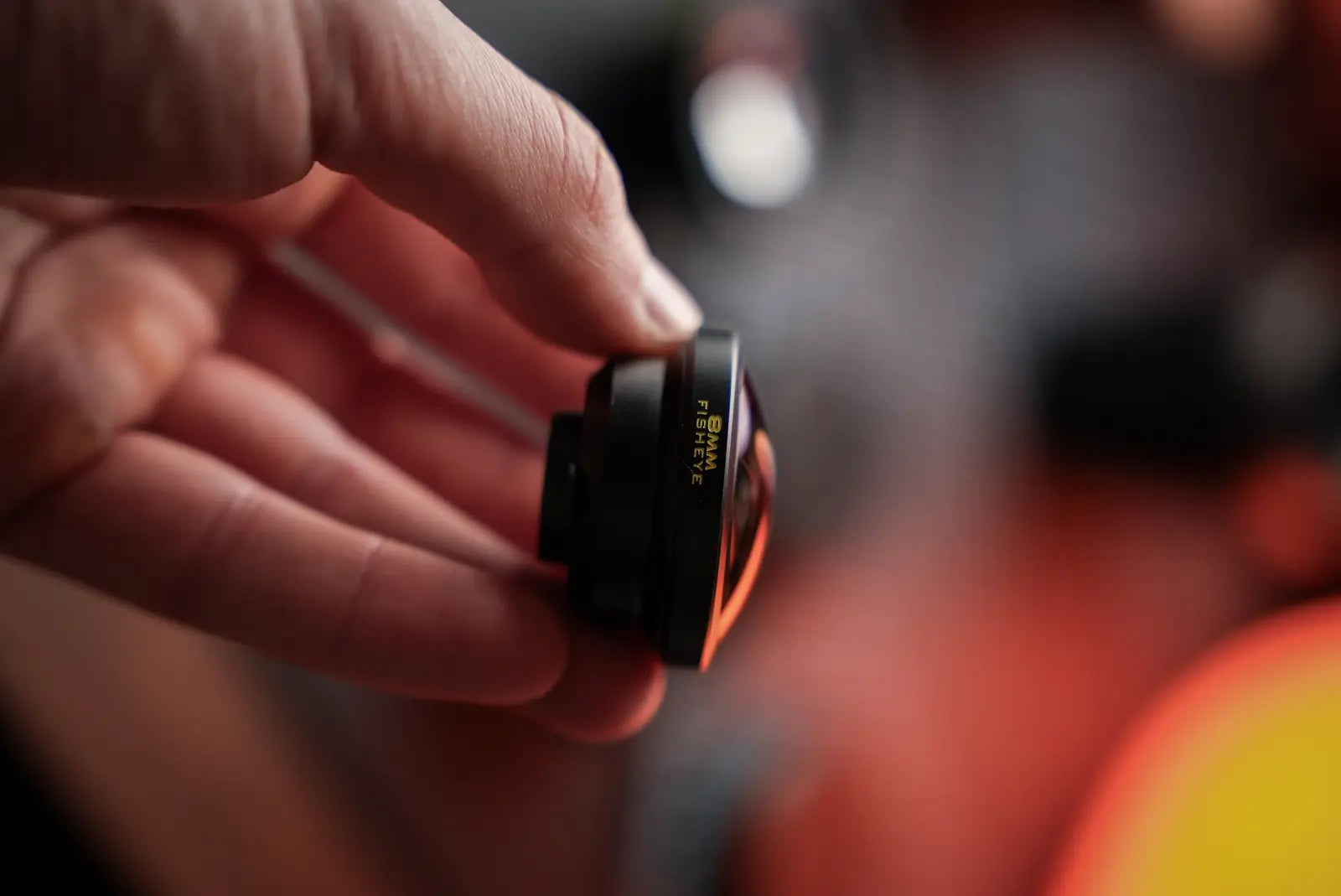 The compact 8mm lens held between two fingers