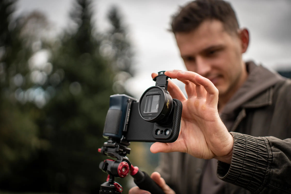 Steven Divish adjusting the flare module on a Freewell anamorphic lens mounted to a smartphone