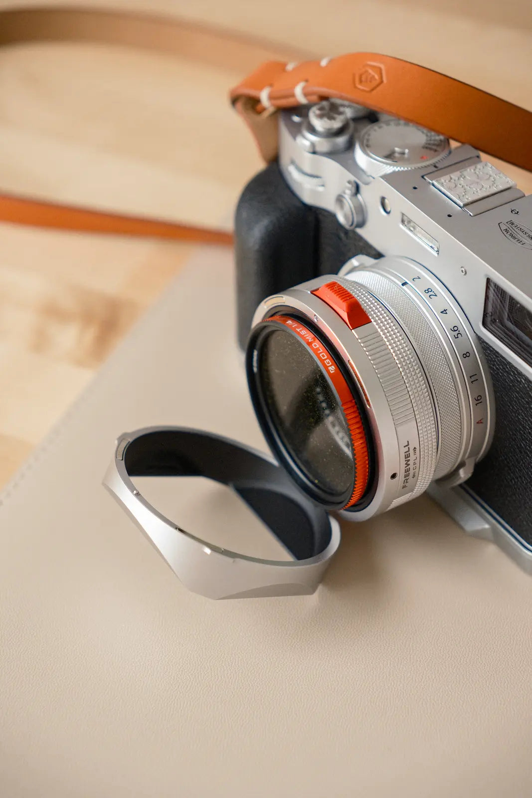 Silver Fujifilm X100VI fitted with the Freewell Real Lens Hood flipped open
