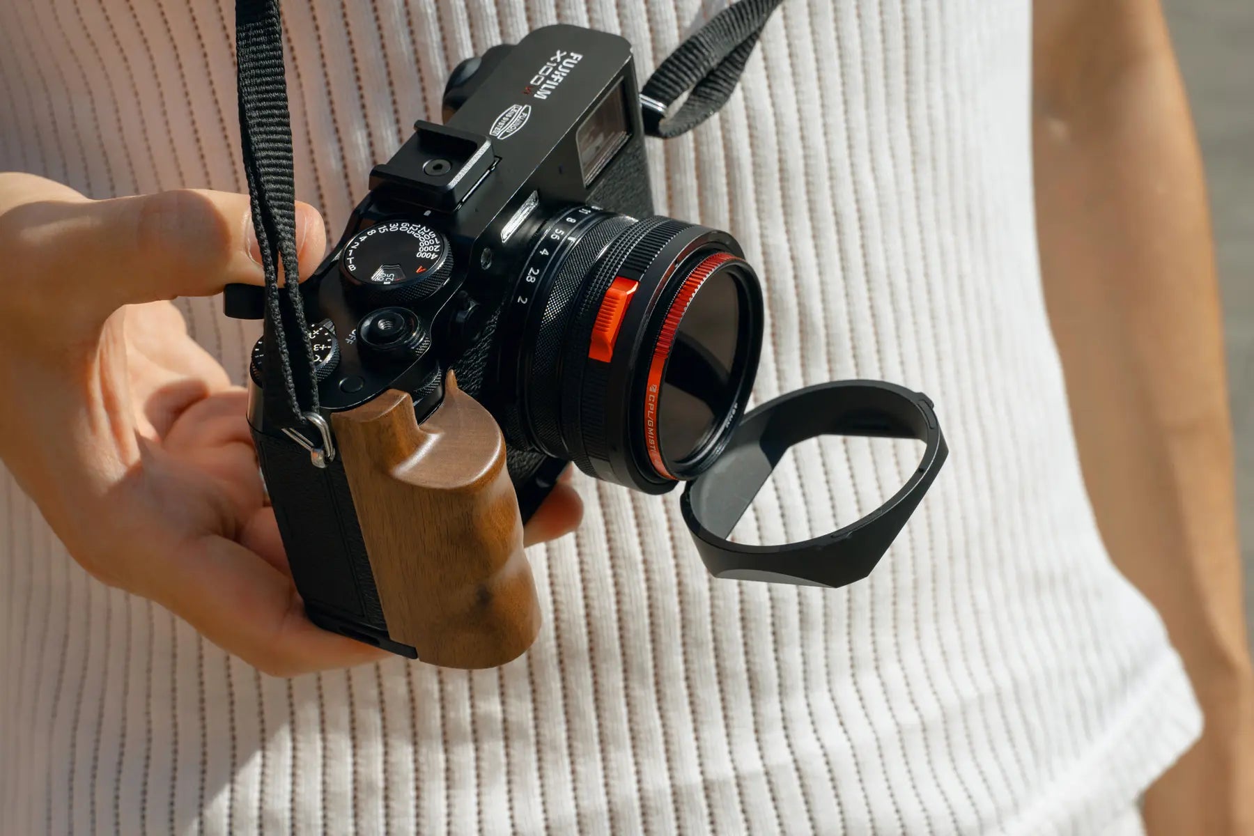 Photographer flipping the Real Lens Hood open on a Fujifilm X100 camera