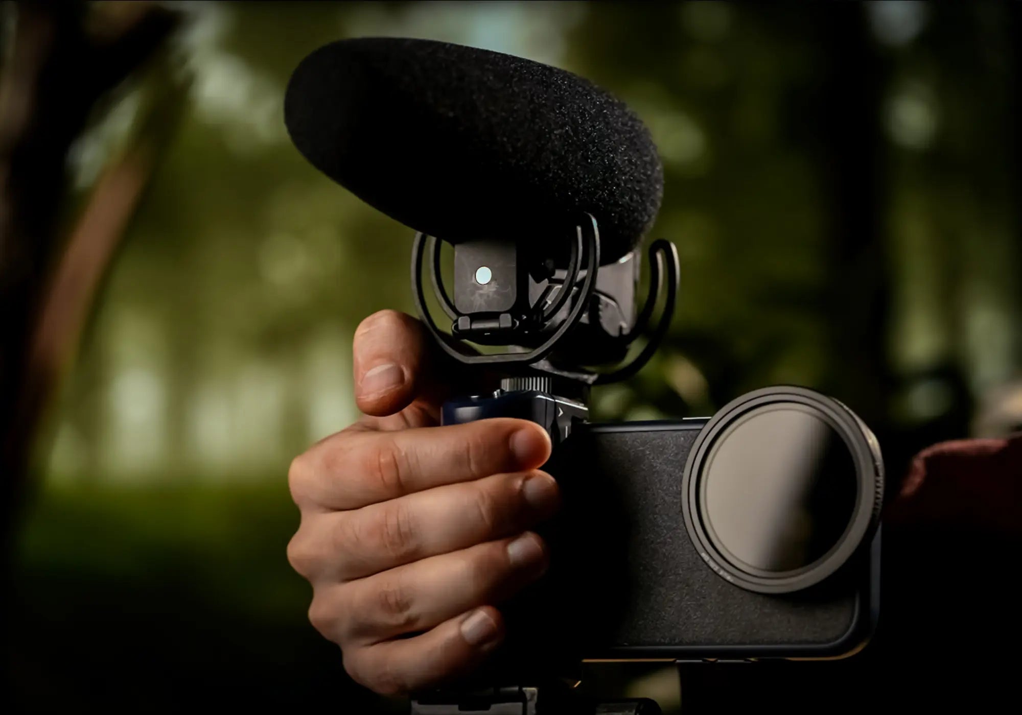 Creator holding an iPhone on Sherpa Grip with a compact microphone
